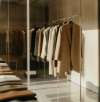 Elegante Kleidungsstücke hängen auf einer Kleiderstange in einem modernen Showroom für Kollektionsmanagement