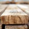 Nahaufnahme gestapelter Holzbretter mit detaillierter Holzstruktur und Maserung für Einkauf, Rohmaterial und Möbelproduktion.