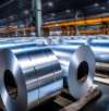 Rows of large, shiny metal coils neatly arranged in a spacious industrial warehouse