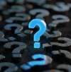 Blue question mark glowing amid black question marks on black background